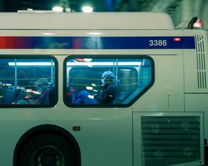 The back of a SEPTA bus, as seen from the street, with masked passangers through the large windows