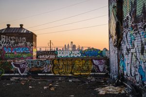 The skyline of Philadelphia, as seen from the rooftop of a building with graffiti along the walls
