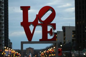 The famous Philadelphia Love statue at Love Park, with the flag-lined Benjamin Franklin Parkway in the background