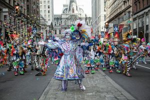 A string band performing at a stop along South Broad Street in the New Year’s Mummers Parade in Philadelphia. City Hall towers in the background.
