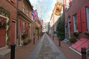 A view down Elfreth’s Alley in Old City Philadelphia, with historic rowhomes on either side of a cobblestone street