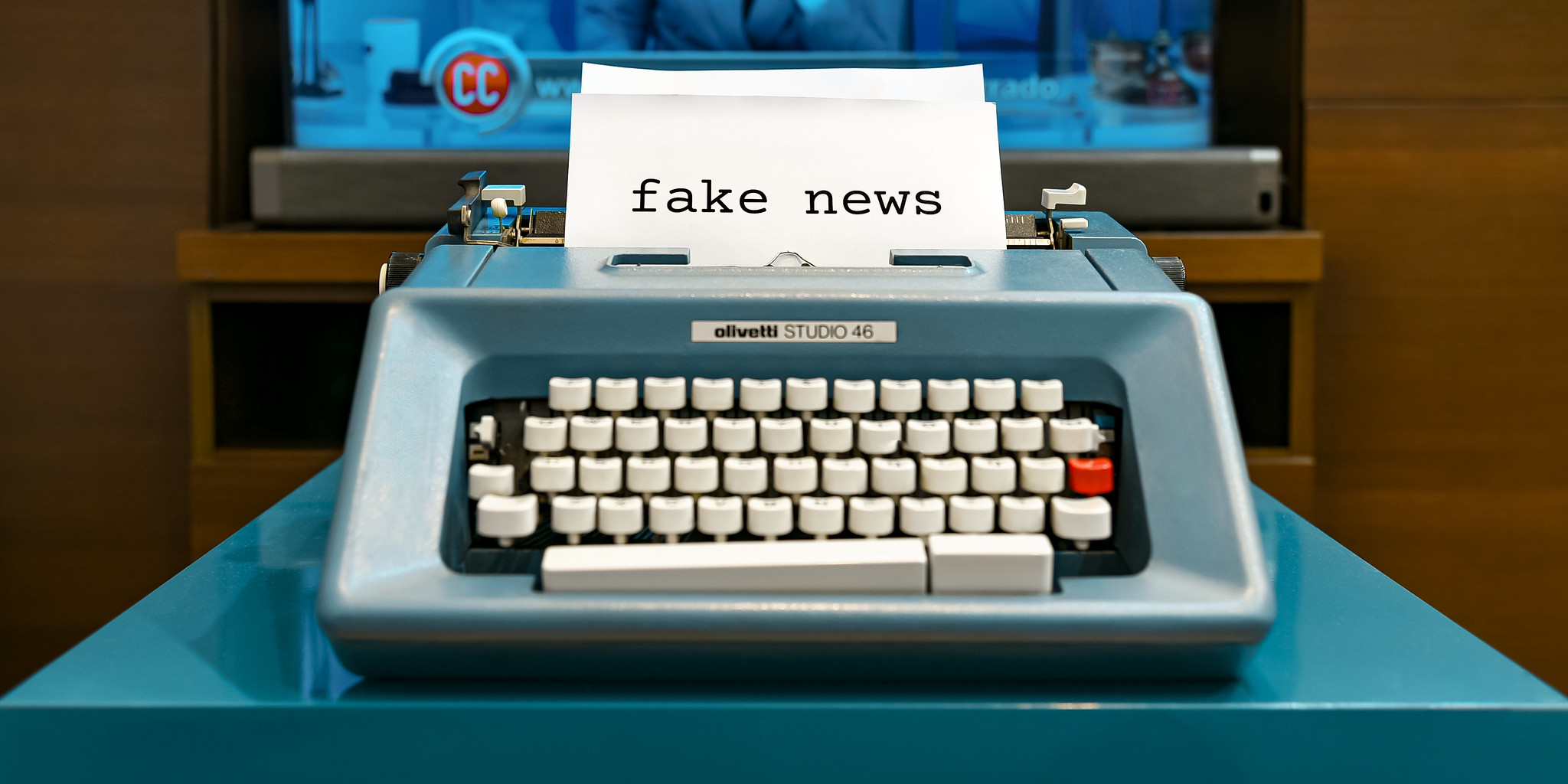 A typewriter with a piece of paper rolled through its carriage. The words FAKE NEWS are typed on the paper.