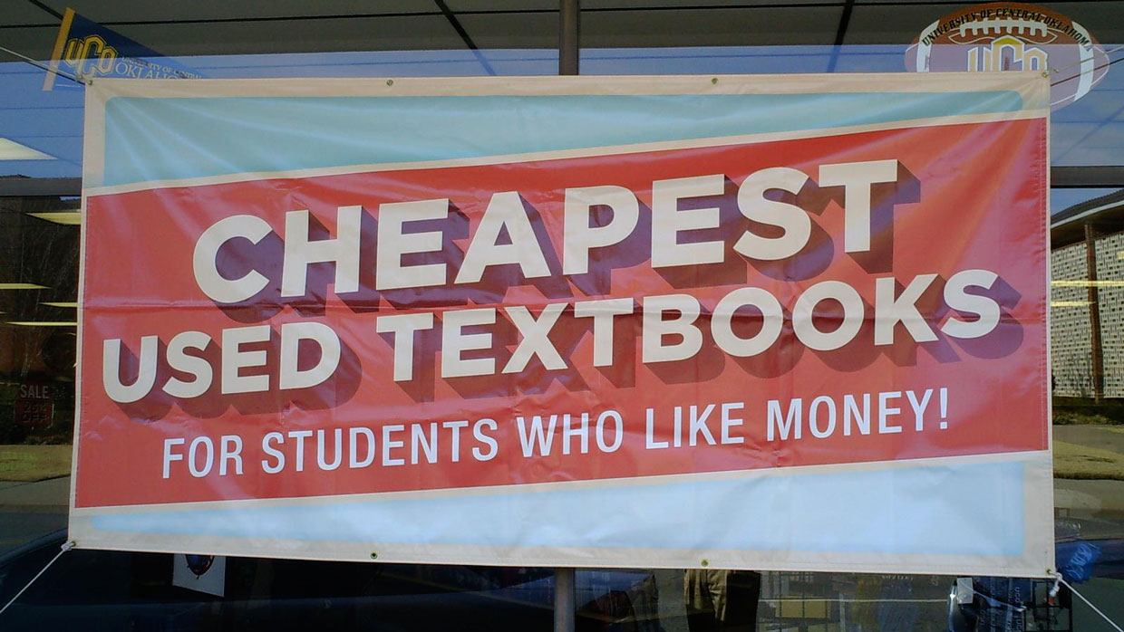 the sign in the store window reads 'Cheapest used textbooks for students who like money!'